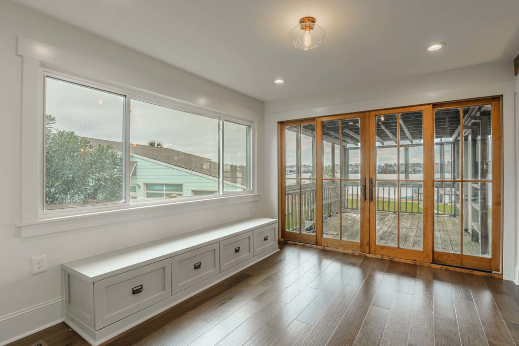 Built in bench in a utility room with french doors overlooking a deck
