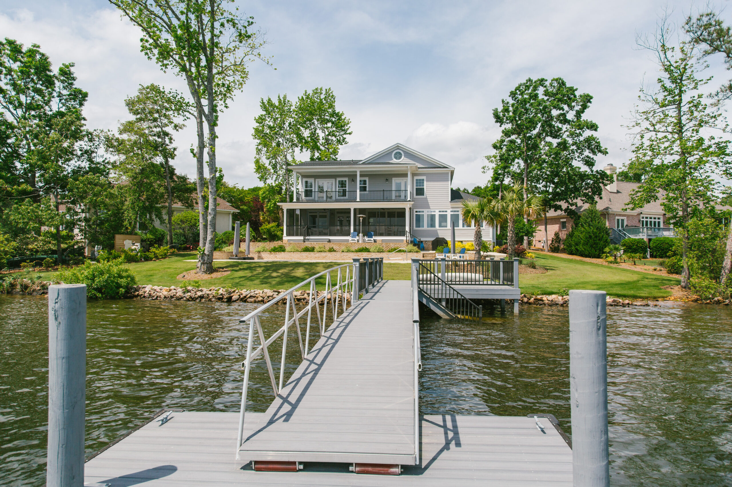 Photo of a two story home with lake access and dock on the water